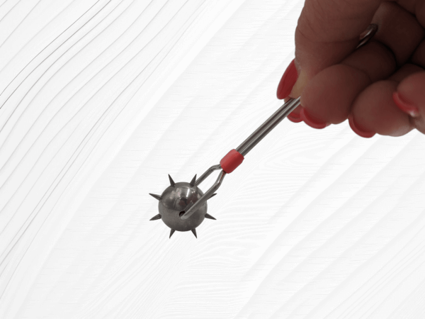 hand holding metal wartenberg wheel with red band